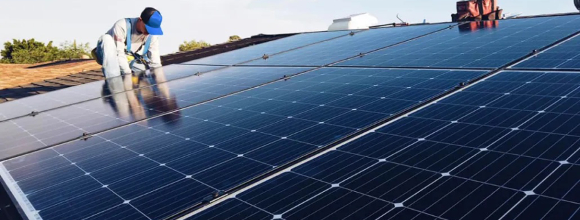 A crew member installs solar energy panels on a home.
