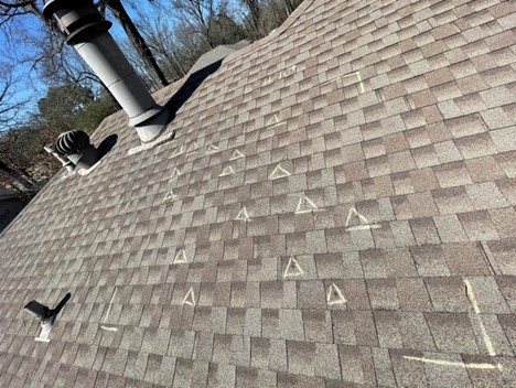 A roof that has been inspected for hail damage with triangles around the spots of damage.