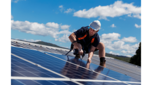 A man screwing in solar panels on top of a rooftop