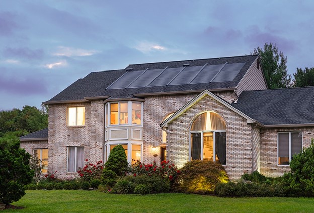 A brick home with solar shingles installed on the roof.