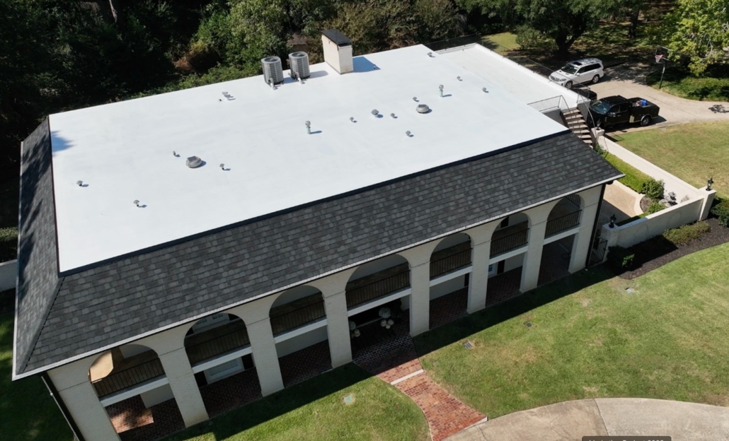 A Mansard-style roof with dark-colored architectural shingles on the straight-pitched sides