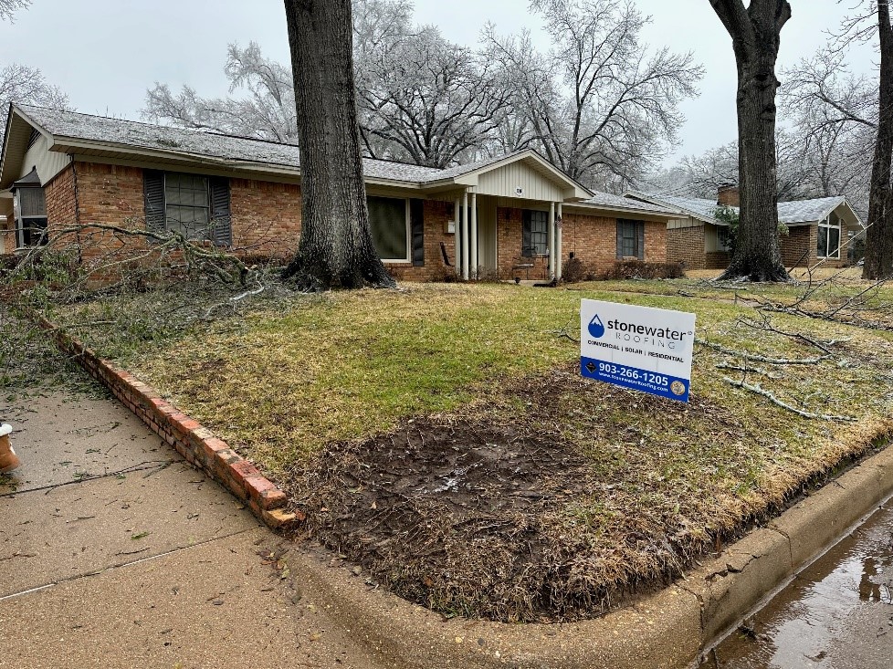 A home with overhanging branches above the roof that illustrates the potential damage it can cause without regular maintenance.