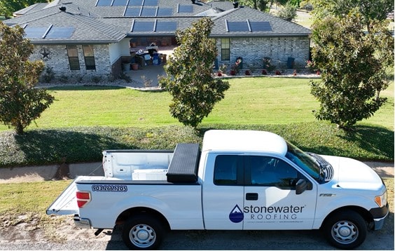 A suburban home with energy-efficient solar panels along its roof.