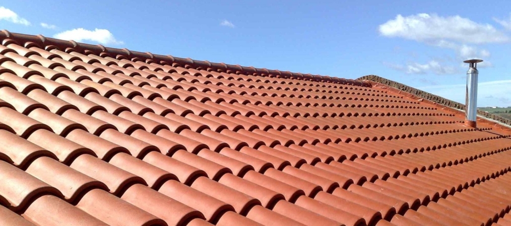 A home with red clay tiles on its roof. This type of roof has a distinctly Mediterranean style, making it popular in warm regions near the ocean.