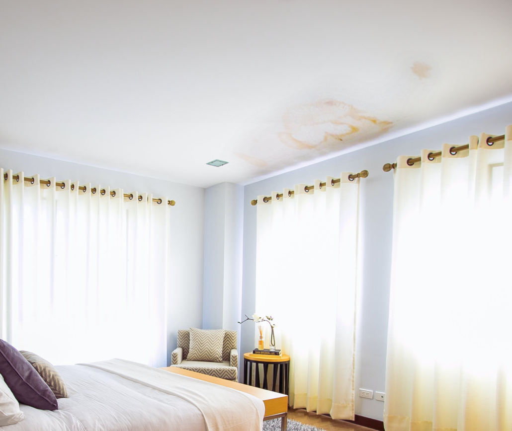 Water damage on a ceiling in a bedroom. A leaky roof can cause unsightly stains and thousands of dollars in damage if not addressed quickly.