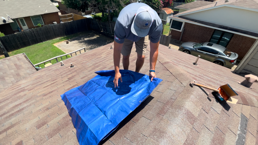 A tarp pulled over a leaky roof to prevent further water damage in the attic. It’s best to address roof leaks immediately when you detect them to prevent serious damage to your home.