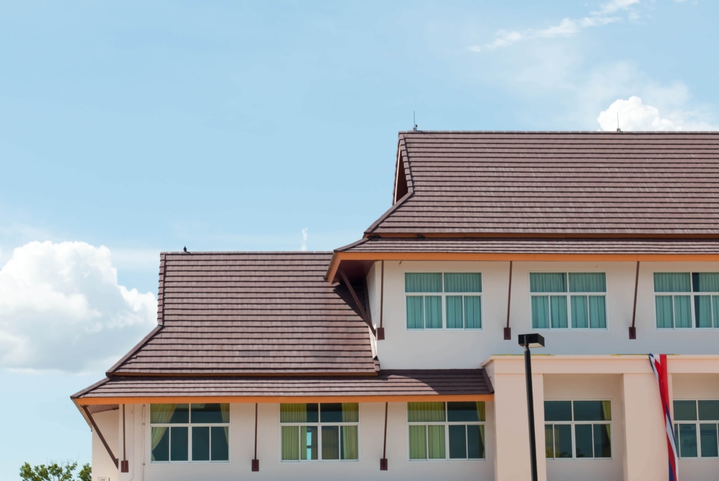 A large building with clay tiles for its roofing materials. Clay tiles are popular on Texas roofs due to their aesthetic synergy with Spanish architecture, which is common in some parts of the state.