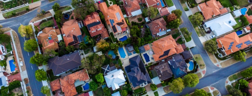 A bird’s eye view of several Texas homes featuring different roof types. Due to the harsh weather in the region, Texas roofs have to have specific materials in order to protect homes.